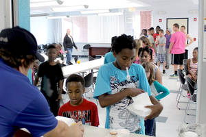 Many kids in line to get meals, multiple ages